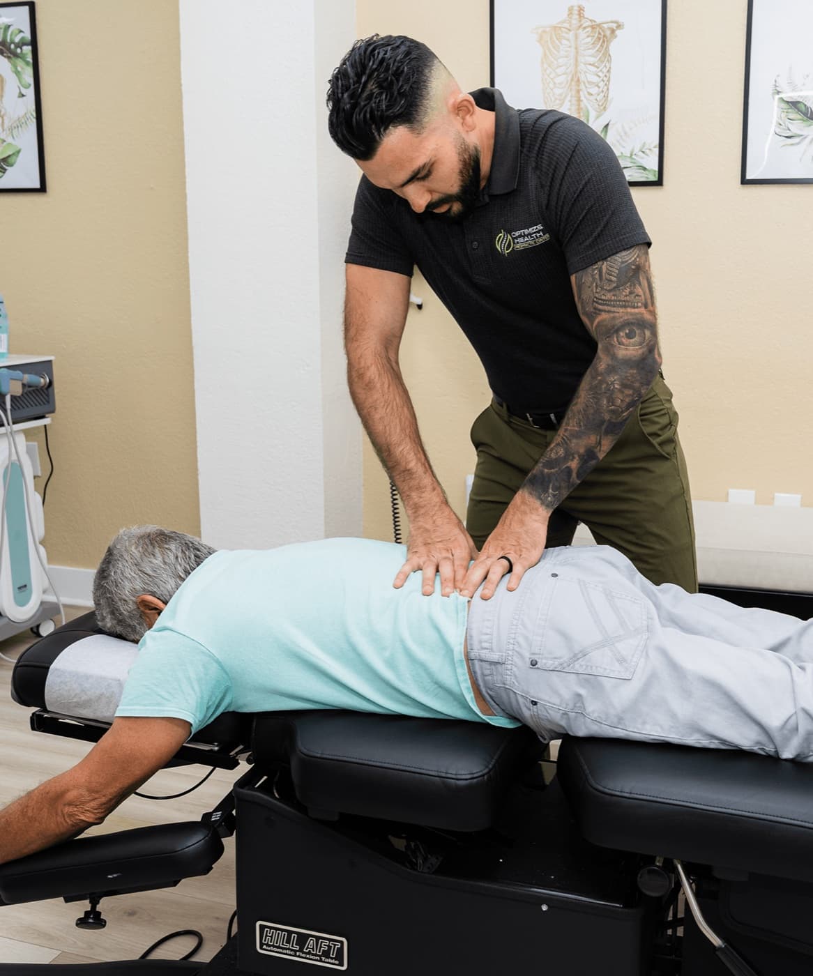 Dr. Denis Chang performing a hands-on spinal adjustment at Optimize Health in Miami Lakes