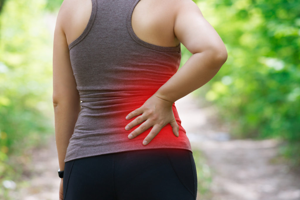 woman suffering from sciatica while walking